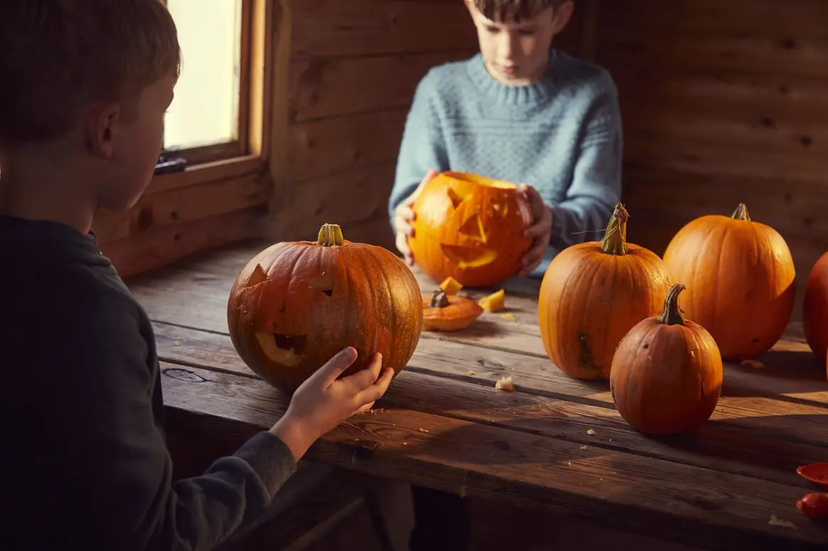 Children carving faces onto pumpkins